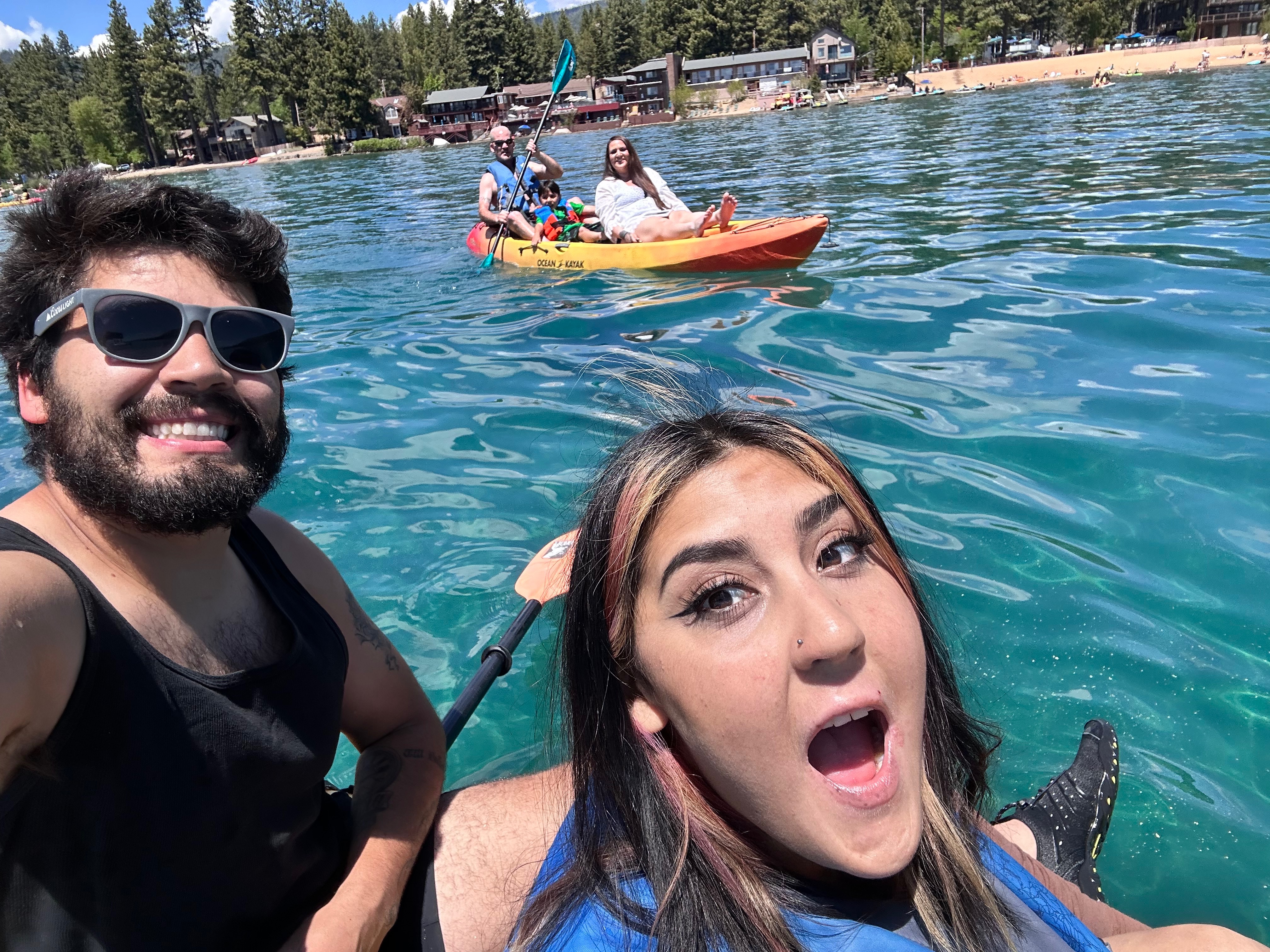 Smiling happy people in canoes, the victim and her brother in the foreground of the photo.